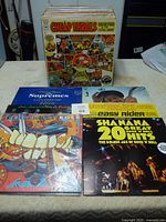 Photo of a box and several vinyl record covers, featuring Cheap Thrills and Shanana Great Rock N Roll Hits among others.