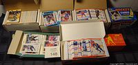 Multiple boxes and stacks of 1990s hockey cards including boxed sets and loose cards.