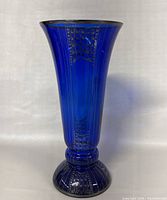 Front view of antique cobalt blue glass vase with silver overlay, showing the flared rim and fine silver decoration on deep blue glass.