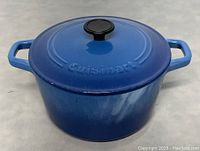 Blue enameled cast-iron lidded pot with Cuisinart logo on lid, showing entire pot and lid in good condition.