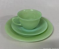 Photo showing the assembled trio of jadeite glass teacup, saucer, and dessert plate stacked together.
