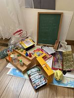 Overview photo of entire arts and crafts collection showing paints, gel pens, marbles, coloring books, markers, chalkboard, and other items