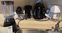 Proctor Silex blender, Betty Crocker jug kettle, Black & Decker food chopper, and Bosch Tassimo coffee maker arranged on countertop.