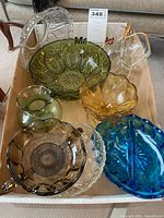 Top view of assorted vintage colored glass bowls and vase showing variety of colors and textures including green, amber, blue, brown, and clear pieces arranged in a tray