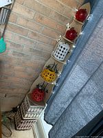 Full view of the wooden corner shelf with ceramic lanterns and red spherical lights on top, surrounded by string lights.