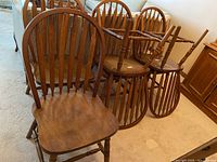 Six mahogany stain hoop back Windsor style dining chairs with turned legs and arrow-shaped back spindles, arranged on carpeted floor.