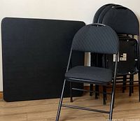 Overview of folding card table and four upholstered folding chairs, one chair placed forward showing condition and design.