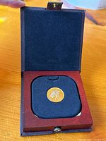 Open keepsake box showing coin in black velvet insert