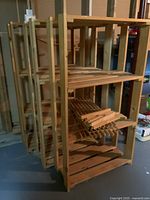 Three wooden shelving units stacked together showing slatted wood shelves and vertical supports.