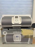 Front view of Altec Lansing inMotion iM7 speaker on original box with an iPod docked in the center.