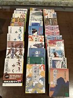 Full view of arranged Japanese novels in three rows, showing covers with Japanese text and diverse traditional artwork and illustrations