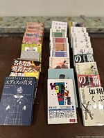 Top view of rows of Japanese novels and manga volumes arranged on a table, showcasing titles and bindings.