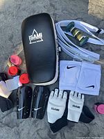 Photo showing ISAMI kick shield, Nike shin guards, ISAMI gloves, Nike wristbands, hand wraps, and mouthguard