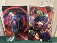 Two 3D litho posters, one Star Wars with Darth Vader and Ahsoka Tano, and one My Hero Academia with Izuku Midoriya in a battle stance, in protective sleeves.