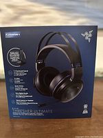 Front view of the Razer Thresher Ultimate for PS4 box showcasing key features including Dolby 7.1 surround sound, wireless connectivity, up to 16 hours battery life, and digital microphone.