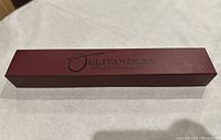 Closed maroon Ollivanders box with branding on top.