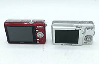 Rear and top view of Kodak EasyShare and HP Photosmart digital cameras side by side showing screens and buttons.