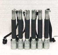Front view of six mini flashlights standing upright, showing metal heads and grips with wrist straps.