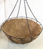 Front view of the hanging metal basket with coco liner inside, showing the chain for hanging and the basket's round shape.