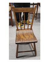 Front view of a wooden slab chair showing its backrest with three vertical spindles, wooden slab seat, and legs.