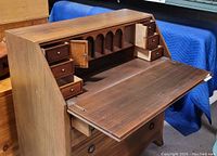 Front angle view of the desk with the fold-down surface open exposing internal small drawers and compartments.