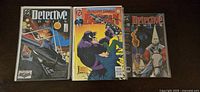 Three individual comic books displayed showing cover art including Detective Comics and Batman Detective Comics Annual.