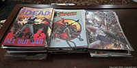 Stack of comic books showing The Walking Dead, Spawn, and other series on top