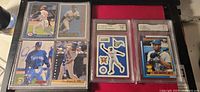 Six assorted Ken Griffey Jr. baseball cards, including two GMA graded cards in protective casing, displayed on a table.