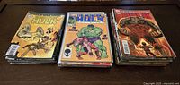 Three stacks of Marvel Incredible Hulk comics with visible front covers showing various issues and cover art