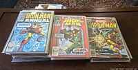 Stack of Iron Man Annual comics and Marvel Iron Man comics.