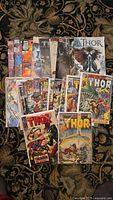 Photo showing a pile of comic books including several Thor issues and Journey Into Mystery with colorful covers.