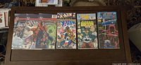 Six comic multi-packs arranged on a table displaying front covers including Batman, Superman, X-Men, Green Lantern, Daredevil, and others.