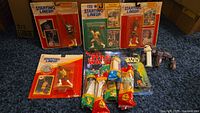Four Starting Lineup sports action figures and assorted Star Wars PEZ dispensers with Mad Magazine comic on floor.