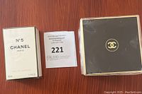 Overview of sealed Chanel N°5 eau de parfum box alongside sealed Chanel packaging and auction lot sticker.