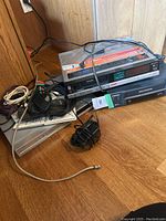 Photo displaying Sony Betamax player on top of Samsung VHS player with various cables and remote control scattered around.