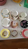 Overhead view of 12 assorted teacup and saucer sets, various patterns