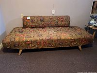 Front view of the Mid Century Modern armless couch, showing fabric pattern and angled legs.