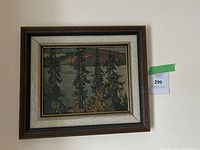 Wall-mounted framed landscape print showing pine trees, river and distant hills