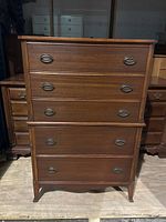 Front view of the antique mahogany 5 drawer highboy dresser showing overall condition and details of brass handles.