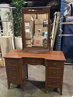 Full front view of mahogany vanity with mirror detached sitting on top. Shows desk surface, drawer arrangement, and mirror design.