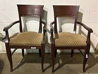 Front view photo of two matching antique style dining chairs with wooden frames and upholstered seats, showing condition and design.