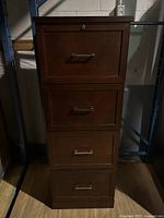 Front view of four drawers of the cabinet with visible handles and lock on top drawer.