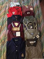 Top-down view of 10 men's golf collared t-shirts in various colors and patterns laid on a bedspread.