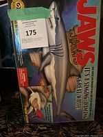 Front of the box showing Jaws logo, great white shark image, and toy features including singing, dancing and motion activation.