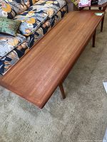 Top view of rectangular teak tabletop showing grain pattern and surface wear.