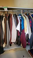 Full closet view showing mixed jackets, shirts and polos on hangers