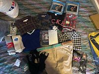 Overview of all clothing items including socks, shirts, and shorts on bed surface showing variety and styles.