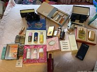 Wide overview of all boxed gift sets, individual bottles, soap, powder and sample vials arranged on bed