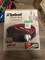 Photo of the front of the original box for the iRobot Roomba 400 robot vacuum cleaner. The box shows the model, a depiction of the vacuum device, and highlights included free filter and floor compatibility.