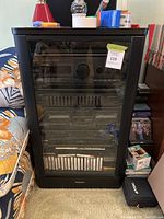 Full view of the black wood cabinet holding all components of the stereo system with cassette tapes visible in lower section.